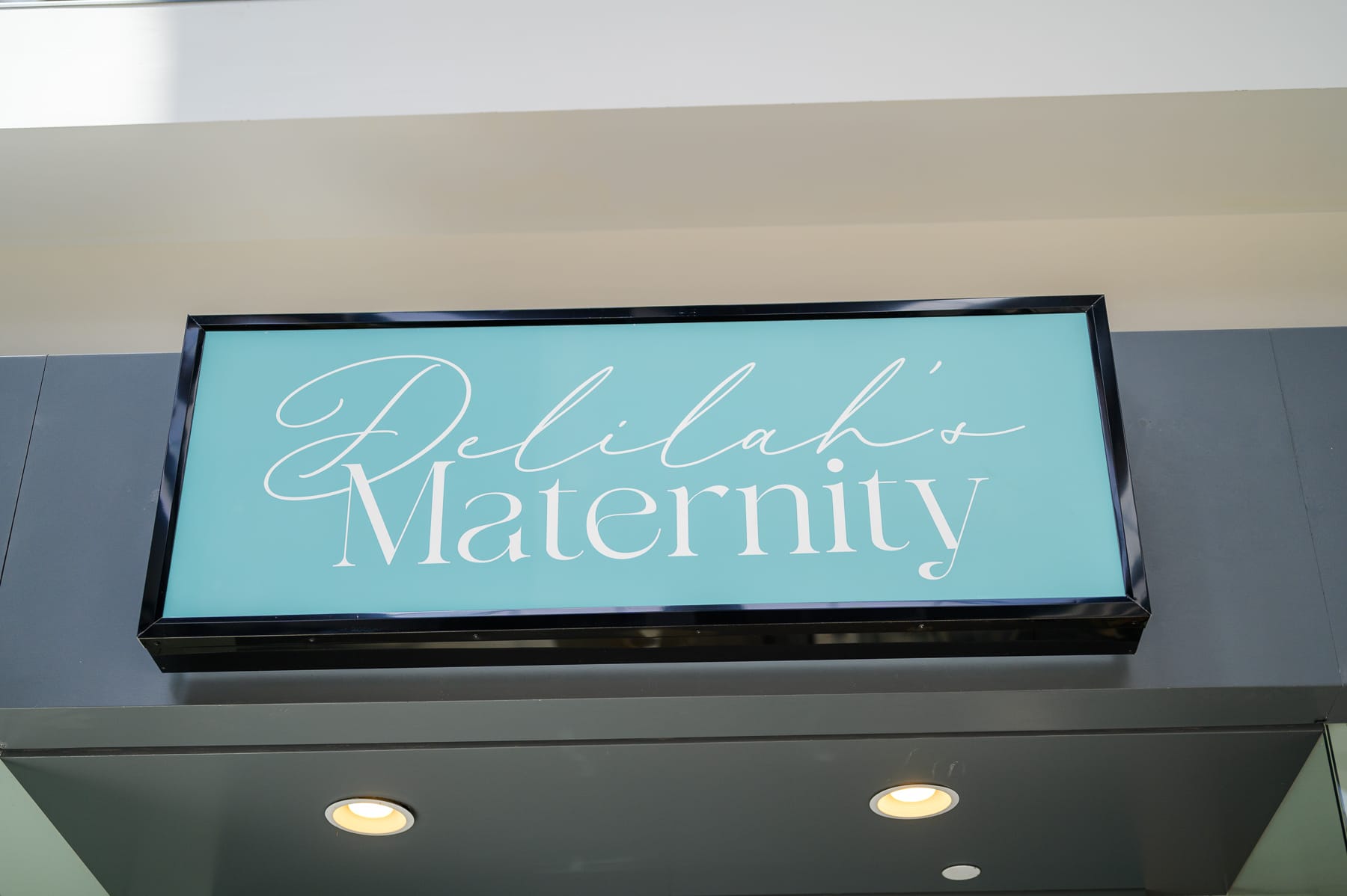 Sign above a storefront that reads "Delilah's Maternity"